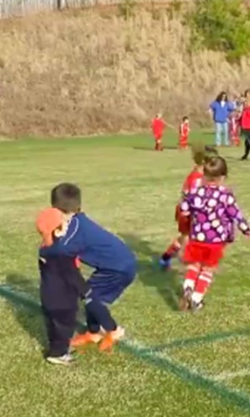 Hug break! Youngster stops mid-game to give his brother a squeeze
